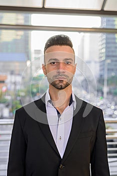 Portrait of handsome young businessman outdoors in city