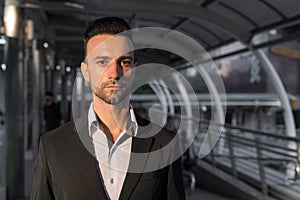 Portrait of handsome young businessman outdoors in city