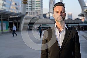 Portrait of handsome young businessman outdoors in city