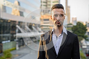 Portrait of handsome young businessman outdoors in city