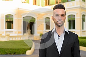 Portrait of handsome young businessman outdoors in city