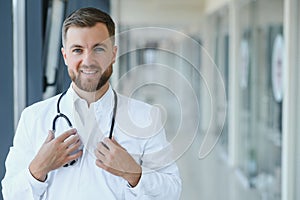 Portrait of handsome young doctor on hospital corridor