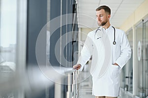 Portrait of handsome young doctor on hospital corridor