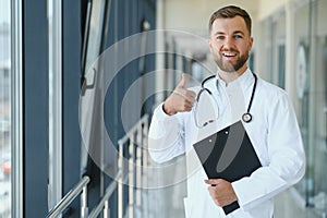 Portrait of handsome young doctor on hospital corridor