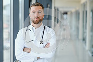 Portrait of handsome young doctor on hospital corridor