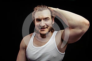 Portrait of a handsome young fair-haired man showing and his big biceps