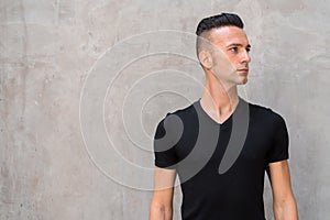 Portrait of handsome young Italian man with undercut wearing black t-shirt and thinking