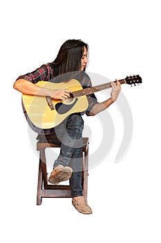 Portrait handsome young male guitarist with long hair sitting and playing acoustic guitar. Asian long-haired man playing acoustic