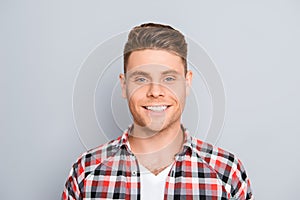 Portrait of handsome young man with beaming smile on gray background