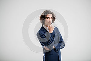 Portrait of a handsome young man in a dark blue business suit on a white background