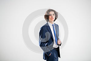 Portrait of a handsome young man in a dark blue business suit on a white background