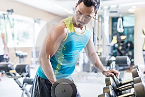 Portrait of a handsome young man exercising bicep curls