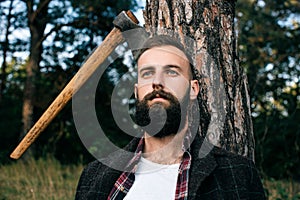 Portrait of handsome young man in forest. Working as a logger photo