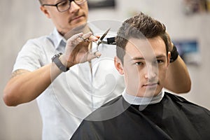 Portrait of handsome young man getting haircut