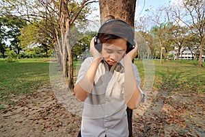 Portrait of handsome young man listening music with headphones in the park.