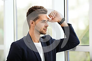 Portrait of handsome young man looking out window