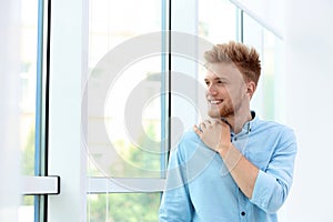 Portrait of handsome young man looking out window