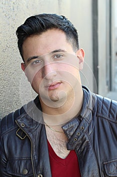 Portrait of a handsome young man with neutral expression at camera, on gray