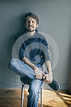 Portrait of a handsome young man smiling against blue gray backg