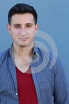 Portrait of a handsome young man smiling at camera, on blue