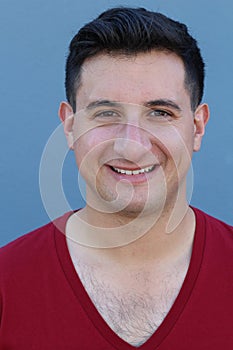 Portrait of a handsome young man smiling at camera, on blue