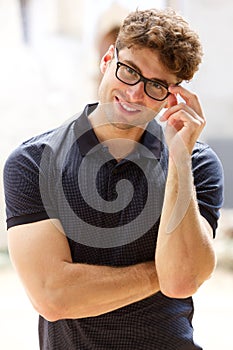 Handsome young man smiling with glasses outdoors