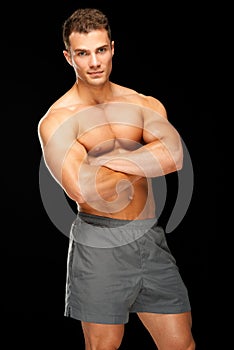 Portrait of handsome young man standing on black