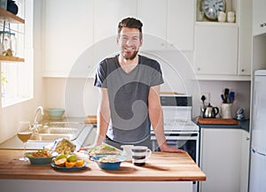 This is my diet for the day. Portrait of a handsome young man standing in front of meals which he has prepared in his