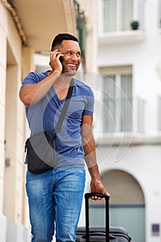 Handsome young man talking on mobile phone with bag