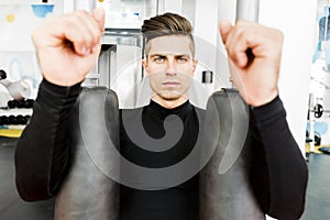 Portrait of a handsome young man training in a gym