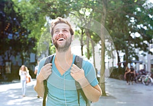 Portrait of a handsome young man walking outdoors with backpack