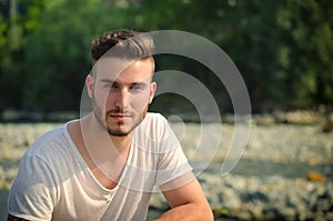 Portrait of handsome young man in white t-shirt outdoors