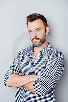 Portrait of handsome young minded man with crossed hands