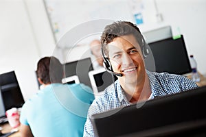 Hes happy to be of service. Portrait of a handsome young sales assistant talking on his headset while working on a