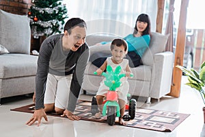 Portrait of happiness daughter playing with father with tricycle