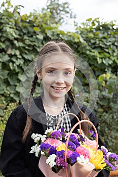 portrait of a happy 8 year old girl with a multi-colored bouquet of flowers
