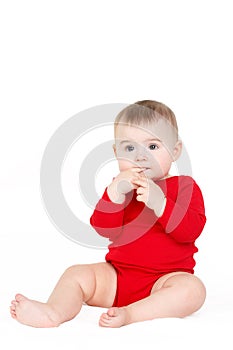 Portrait of a happy adorable Infant child baby girl lin red sitting happy smiling on a white background