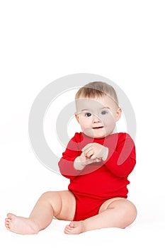 Portrait of a happy adorable Infant child baby girl lin red sitting happy smiling on a white background