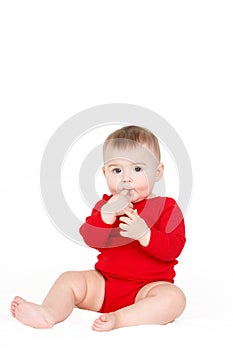 Portrait of a happy adorable Infant child baby girl lin red sitting happy smiling on a white background