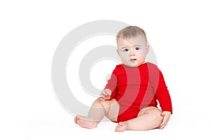 Portrait of a happy adorable Infant child baby girl lin red sitting happy smiling on a white background