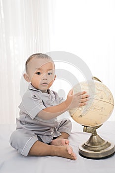 Portrait happy of a adorable little boy playing globe