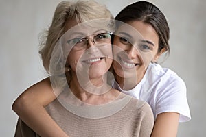 Portrait of happy adult daughter hug senior mom