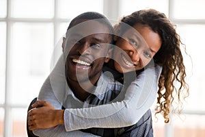 Portrait of happy african american couple embracing looking at c