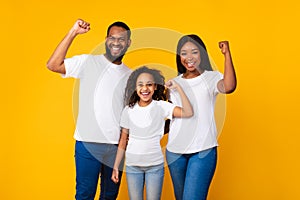 Portrait of happy African American family shaking fists at studio