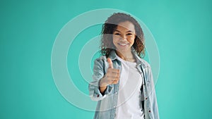 Portrait of happy African American girl showing thumbs-up and smiling