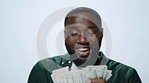 Portrait of happy african american man counting money on grey background.