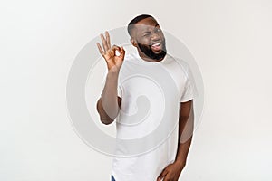 Portrait of happy african-american man showing ok sign and smiling, over white background.