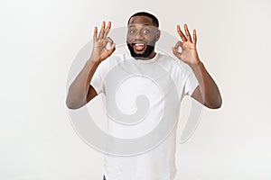 Portrait of happy african-american man showing ok sign and smiling, over white background.