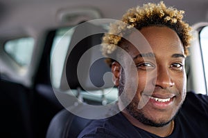Portrait of a happy African-American man sitting in his newly purchased car