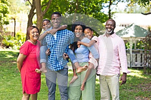 Portrait of happy african american multi-generational family standing together in backyard